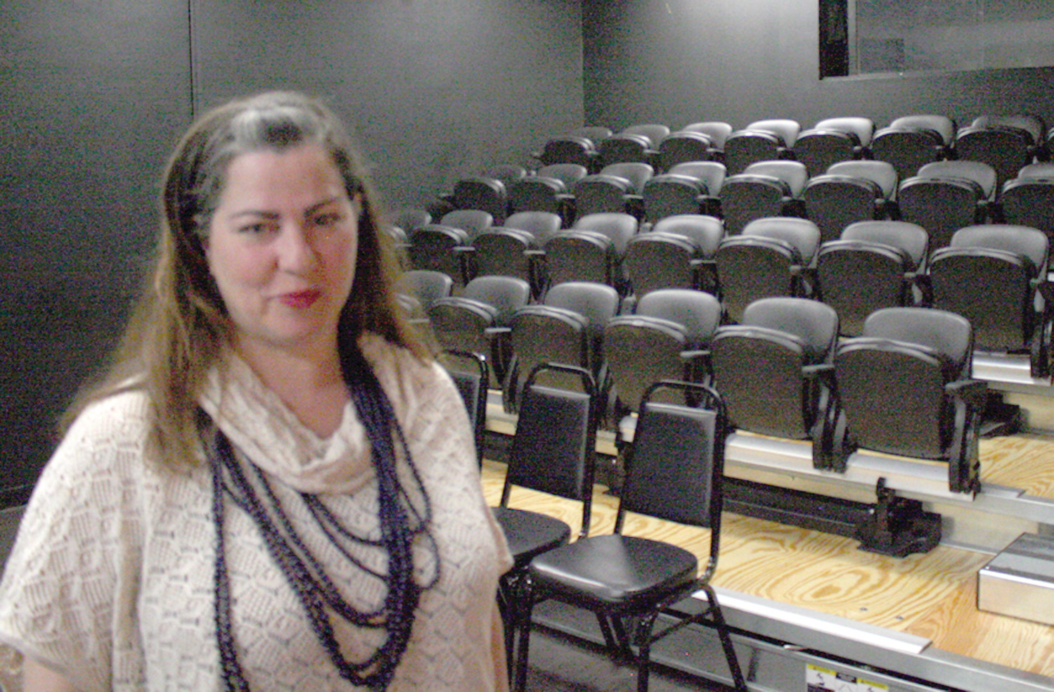 HOME MOVIE THEATER: Elaine McKenna-Yeaw shows the newly done movie theater seats, which holds 50 people and has a projector/screen as well as open floor space for theatre productions.